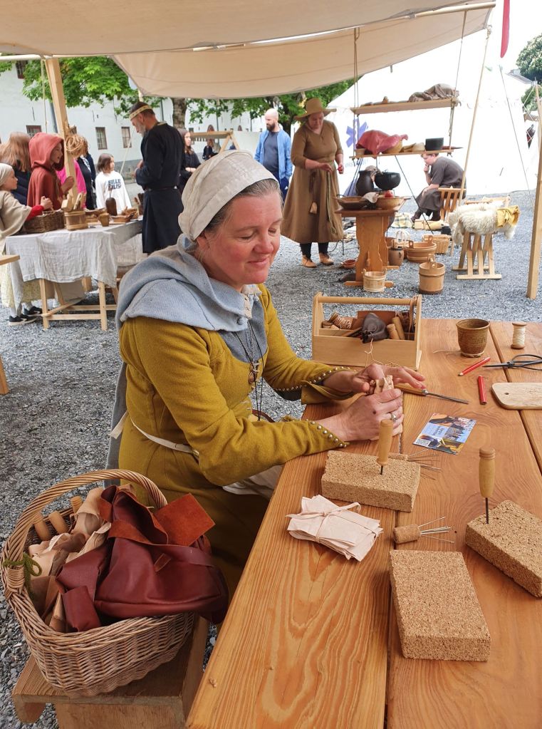 Lena sitter med publikum og lager skinnpunger